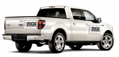 White pickup truck with advertisement on side.