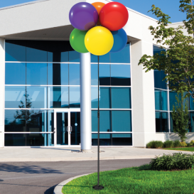 Colorful balloons in front of modern building.