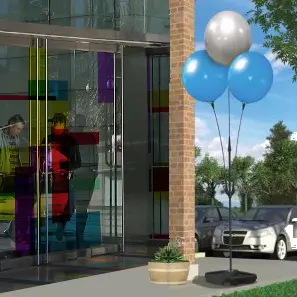 Balloons outside glass entrance with colorful panels.