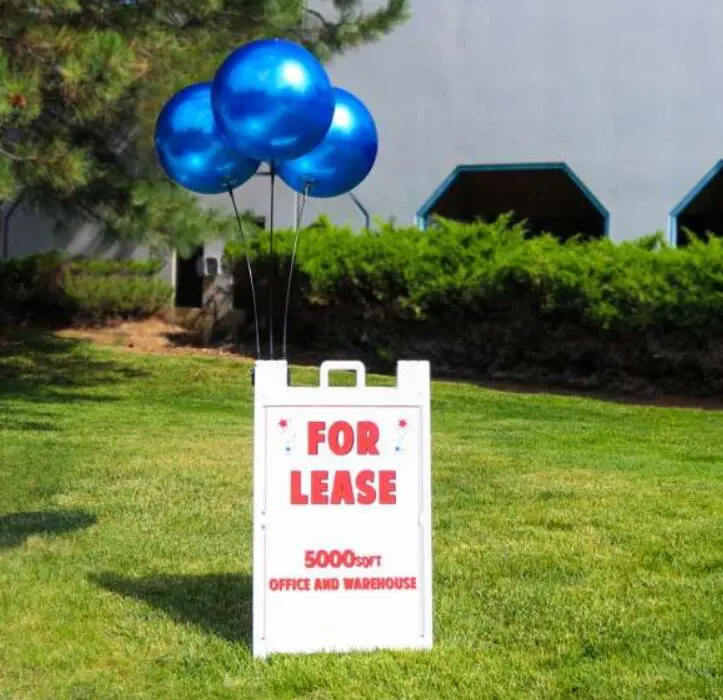 For lease sign with blue balloons outside.