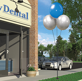 Dental office with balloons and parked cars.