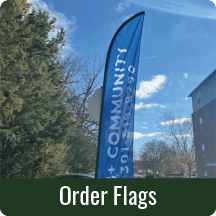 Blue promotional flag near building and trees.